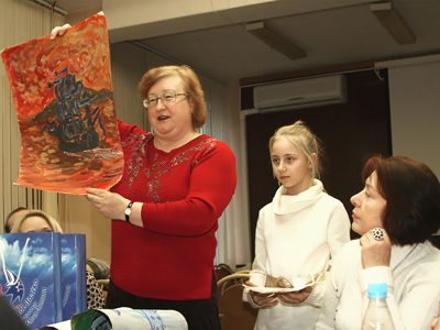Елена Егорова показывает работу Леры Сиделёвой членам литобъединения